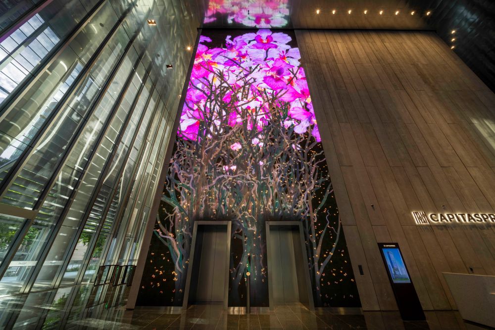 At the lobby of CapitaSpring is a dynamic artwork of vibrant florals on an 18-metre-high media wall by renowned international art collective teamLab.